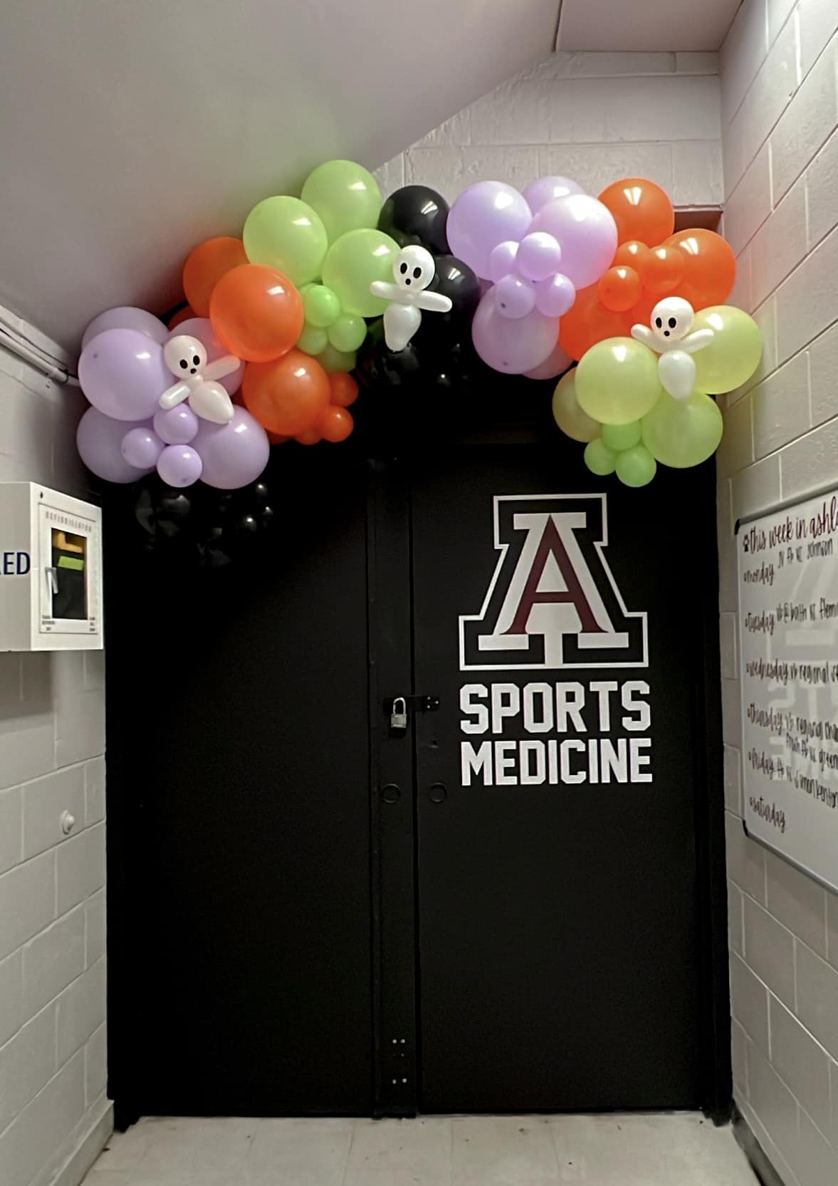 Sports Medicine vinyl decal with a block A logo on a black locker room door