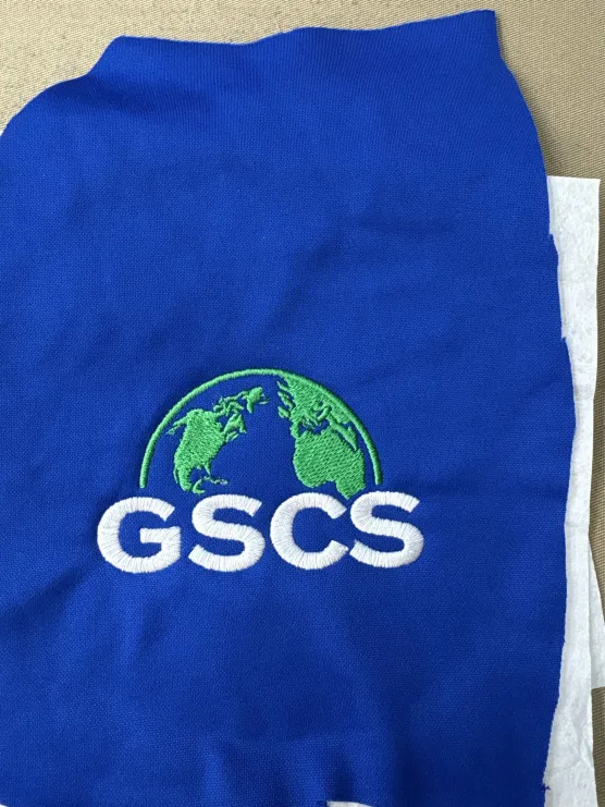 GSCS globe logo embroidered on a royal blue shirt