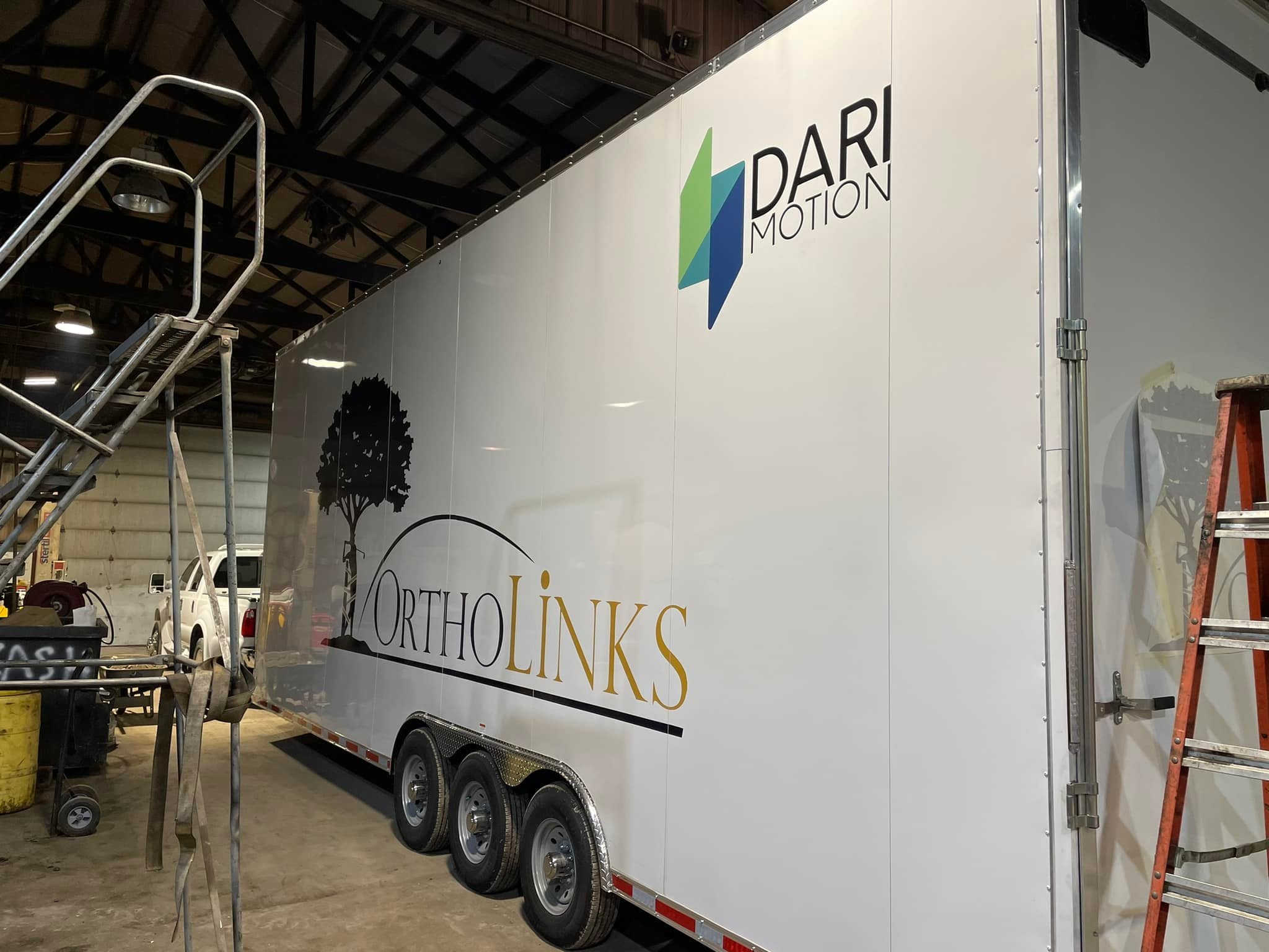 OrthoLinks and DARI Motion graphics on a white enclosed trailer